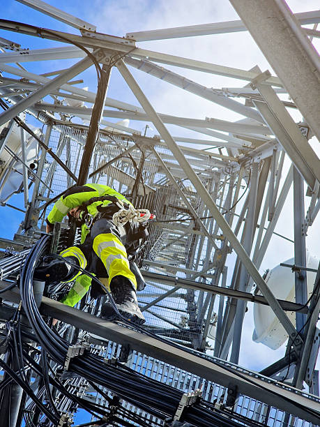 istock Engineer utility infrastructure worker at big steel mast working with radio link 2216973970