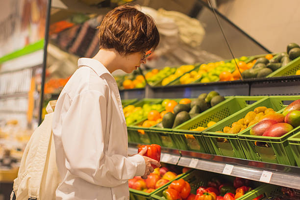 istock Young woman in vegetable department. Select peppers 2216974540