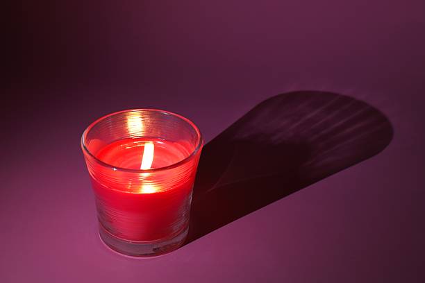 istock a red candle in a transparent glass burns and creates a cozy light 2216975052
