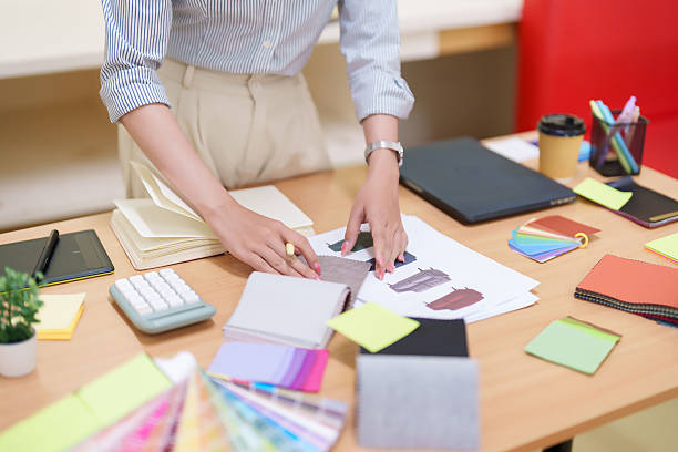 istock Asian Women Interior Designer Chooses Fabric Samples for Home Renovation Project with Color Palette Interior Design Studio Workspace for Home Decorating Stylish Creative Workplace 2216977922