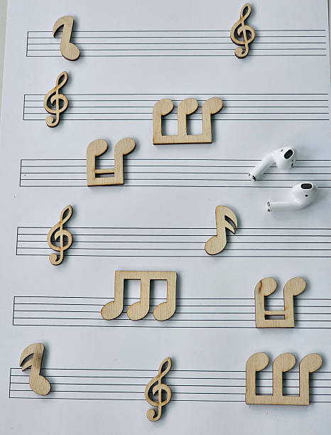 istock Musical notes and earphones arranged on sheet music for a creative and playful musical 2216979342
