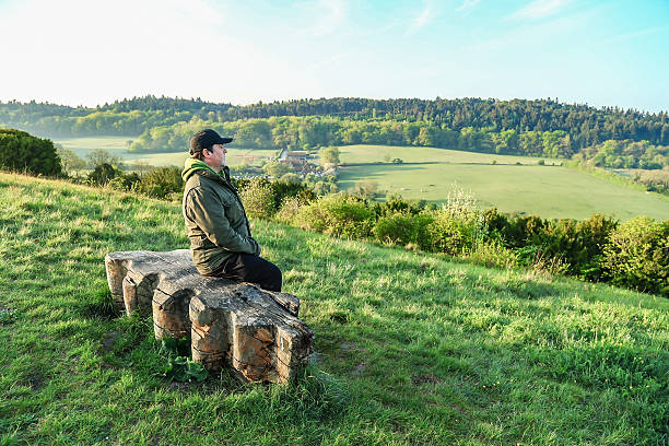istock A lonely man sitting on the bench looking at the view Surrey England 2216980263