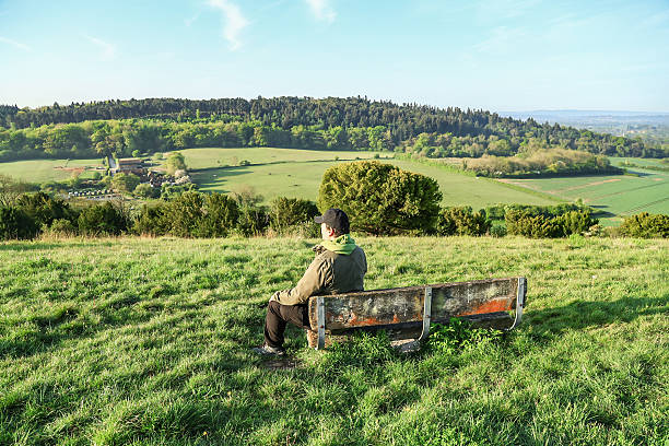 istock A lonely man sitting on the bench looking at the view Surrey England 2216980286