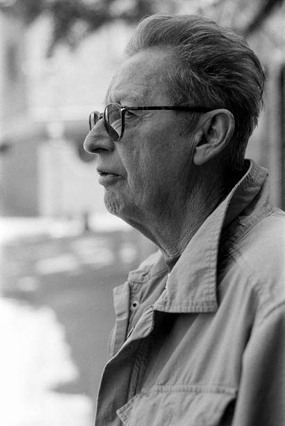 Senior man wearing glasses and a jacket is looking away