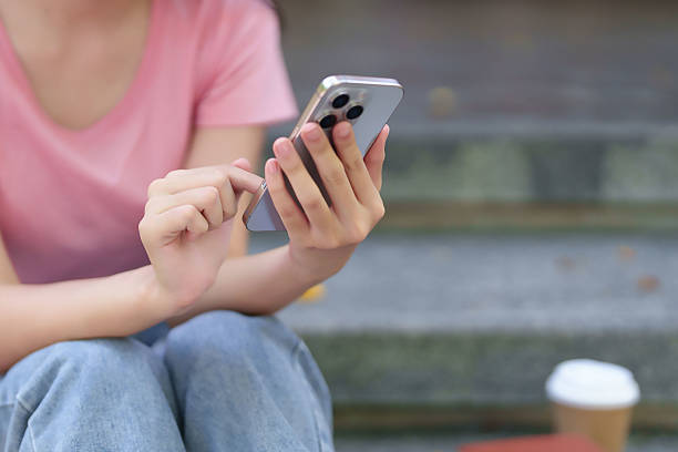 istock Asian Young Woman Using Smartphone on Steps Mobile App Education Online Learning Communication Lifestyle Relaxing Searching Information Coffee Cup 2216984563