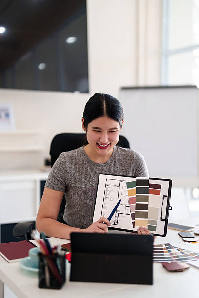istock Young architect presenting interior design ideas through tablet during online meeting in creative office 2216985918