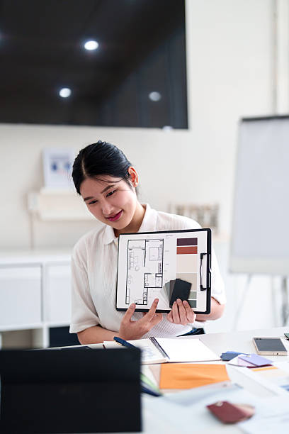 istock Young architect presenting interior design ideas through laptop during online meeting in creative office 2216985991