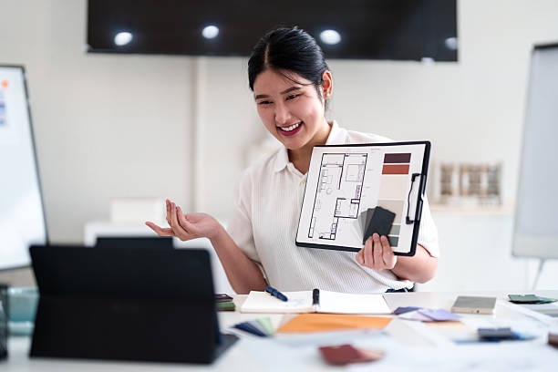 istock Young architect presenting interior design ideas through laptop during online meeting in creative office 2216985997