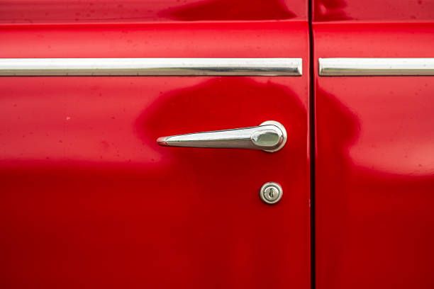 Close up of classic red car door handle.