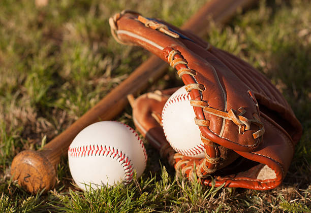 istock baseball bat, ball and glove on grass 2216990903