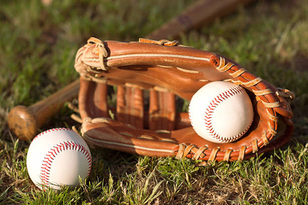 istock baseball bat, ball and glove on grass 2216990933