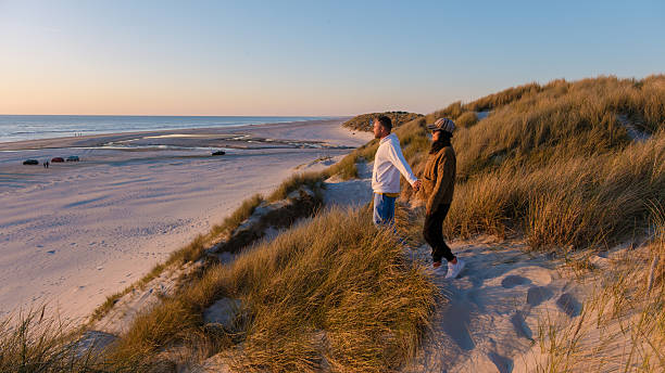 istock Couples enjoy a romantic sunset stroll on the sandy beaches of Denmarks beautiful coastline 2216992460