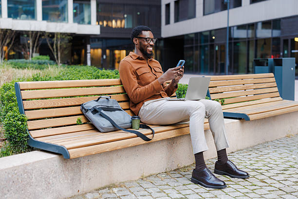 istock Man working on a bench with laptop and phone outdoors 2216994014