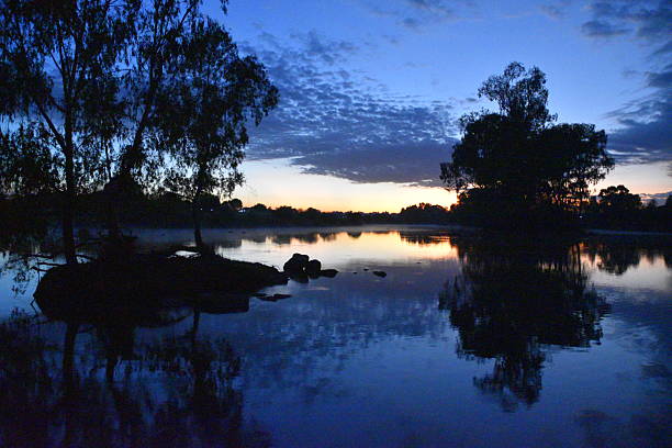 istock Tranquil Sunrise Over a Calm Lake With Trees and Morning Mist 2216996691