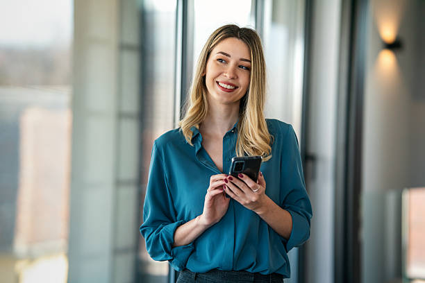 istock Happy businesswoman using mobile phone while analyzing weekly schedule in corporate office 2216998048