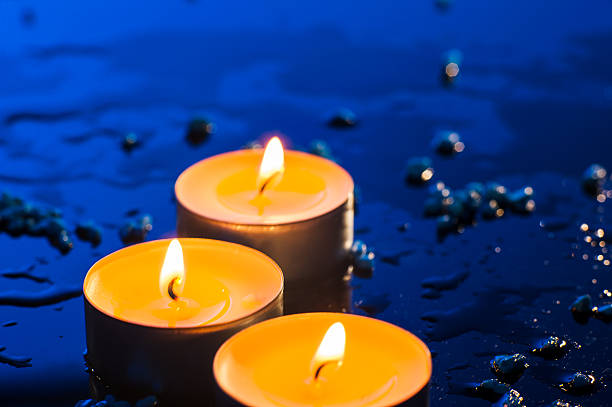 Small candle flames burn against a deep blue background. Each candle radiates romantic glow. These three flames become the centerpiece of the festive décor.