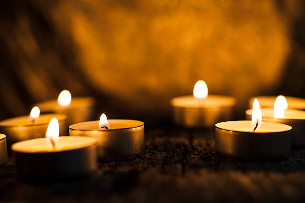 istock Countless small tealight candles burn on a dark brown background 2217003303