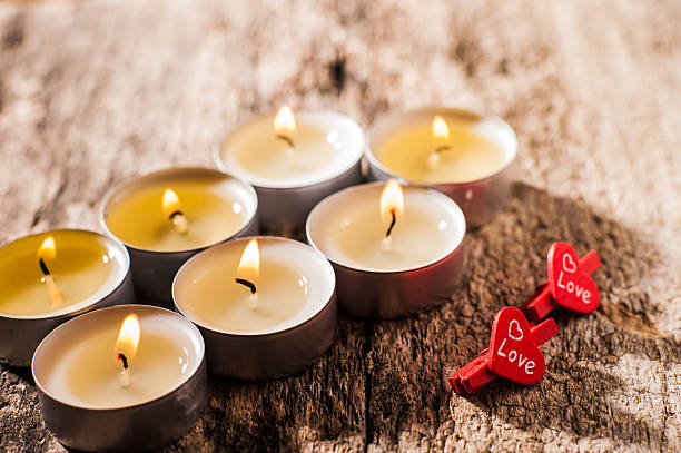 Burning candles sparkle like stars on a dark surface. The light of each candle envelops the space with coziness. These flames are perfect for festive romance.