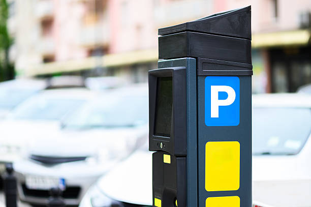 istock A modern parking meter stands in an urban environment surrounded by various parked vehicles on a busy street 2217003343