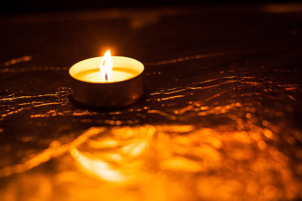 A burning candle lights the darkness with a gentle flame. The New Year candle stands at the center, creating a festive mood. The Valentine candle light adds warmth to the moment on Valentine's Day.