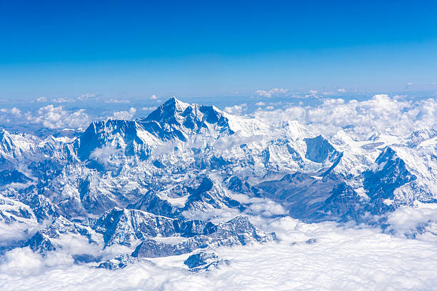 View of the snow-capped peaks of the Himalayas above the clouds from a airplane in Nepal.