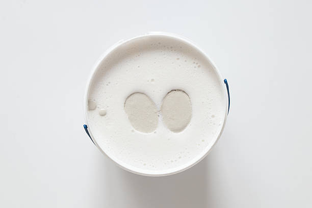 Hands mold in a bucket with pink mixture for making a cast, the process of preparing a mold for casting hands from plaster stock photo