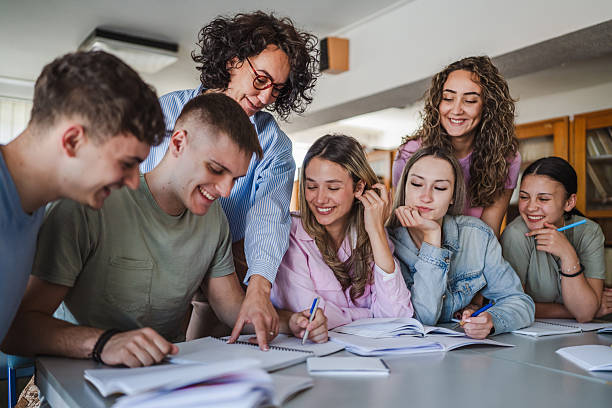 istock Group of high school students work on project with teacher in library 2217009565