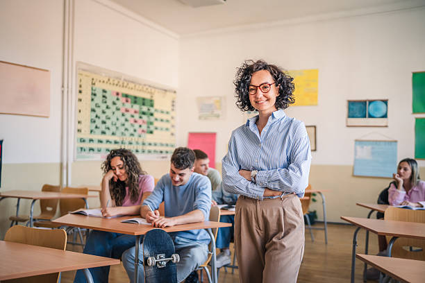 istock A mature female teacher stand confidently in her elementary classroom 2217010582