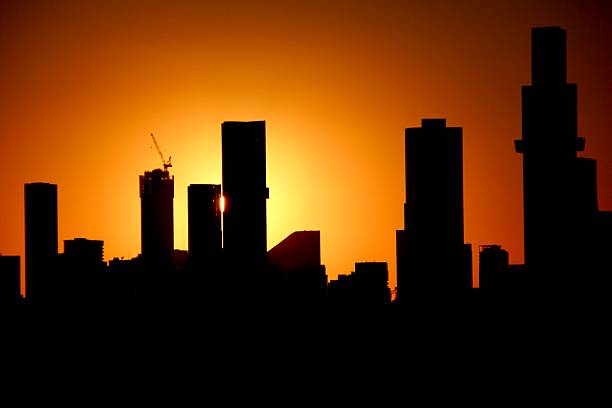sun glow behind towers with a construction crane