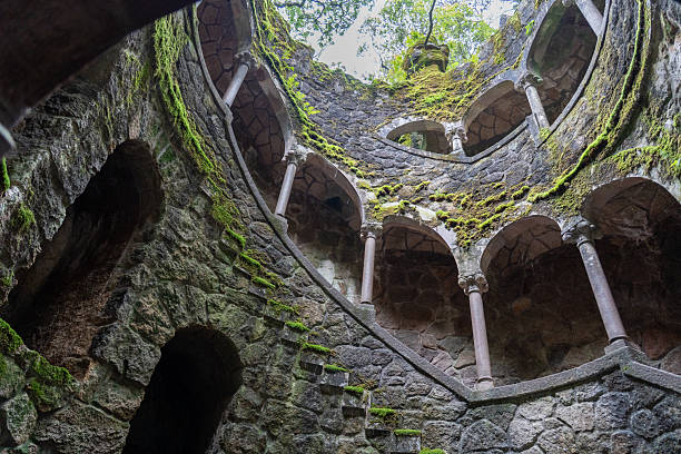 istock An evocative upward view from inside a deep stone corridor. Rough walls and layered niches guide the eye toward a luminous opening framed by hints of greenery 2217011501