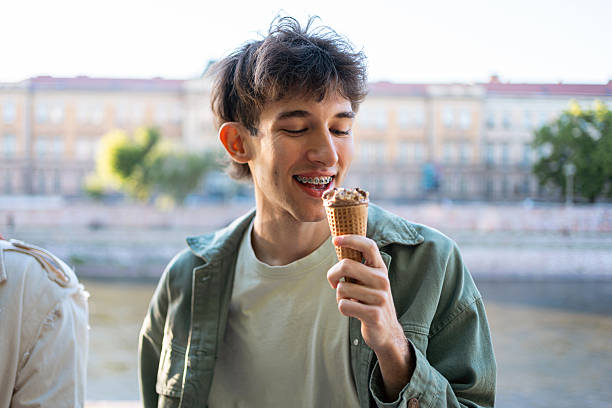 istock Young man enjoying an ice cream outdoors on a sunny urban day 2217011775