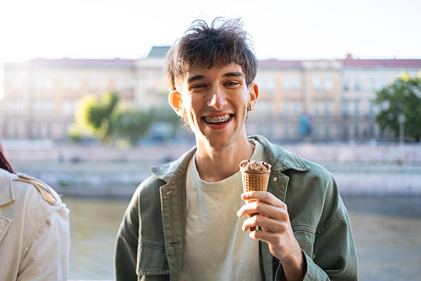 istock Smiling young man enjoying ice cream outdoors with scenic background 2217011781