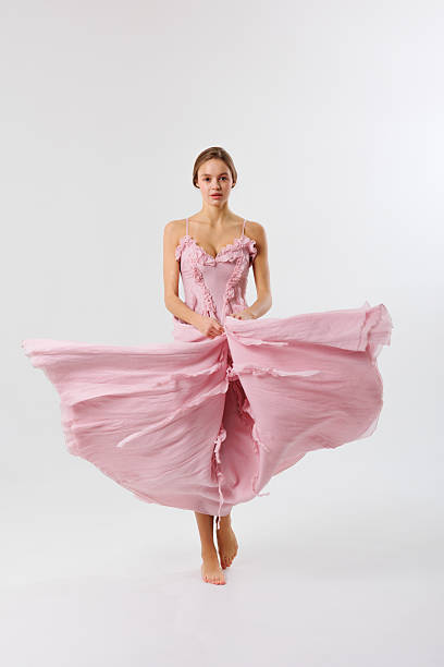 istock Elegant dancer in flowing pink dress showcases graceful movement in studio setting 2217013441