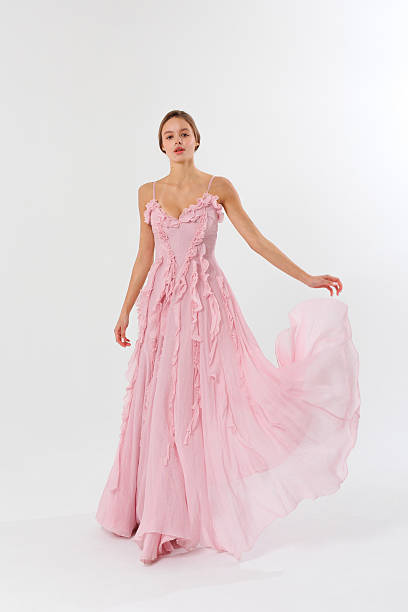 istock Elegant model showcases a flowing pink evening gown in a minimalist studio setting during a fashion shoot 2217013496