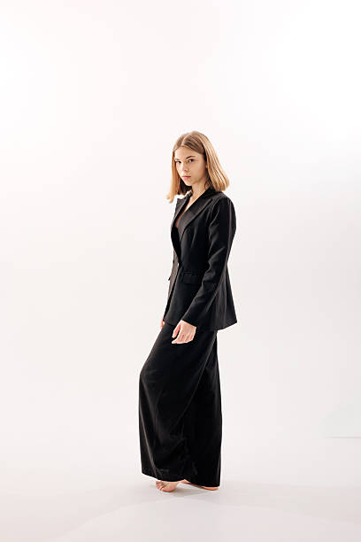 istock Model showcases stylish black suit in minimalistic studio setting during photoshoot 2217013505
