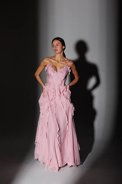 istock Elegant model showcases pink evening gown with intricate design in a studio setting during a fashion event 2217013630