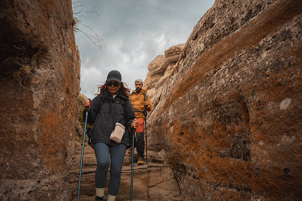 Hikers ascending challenging stone steps in a narrow canyon, showcasing adventure and determination