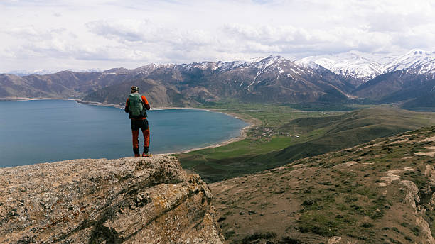 istock Hiker contemplating majestic mountain view from rocky cliff 2217019041