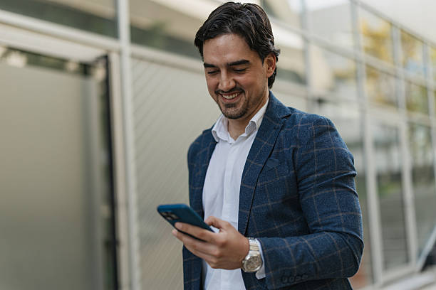 istock Happy man engaged with smartphone outdoors 2217021003
