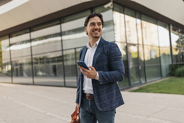 istock Man looking up happily while holding phone 2217021352
