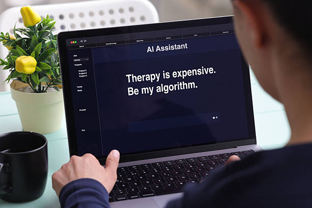 istock Woman using laptop with humorous AI therapy message on screen 2217024121