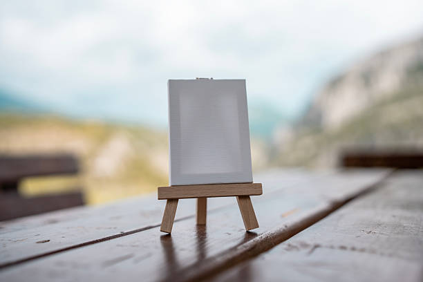 Small Wooden Easel Holding Canvas Outdoors on Rustic Wooden Table