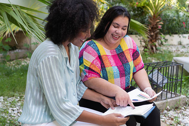 istock Two businesswomen collaborating on documents outdoors, embracing body inclusivity 2217028974