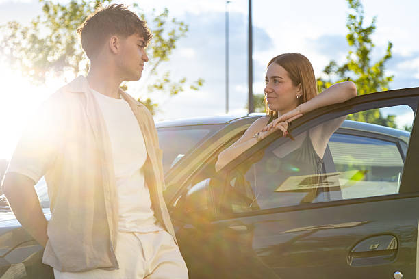 istock Young couple talking next to their car at sunset 2217030359