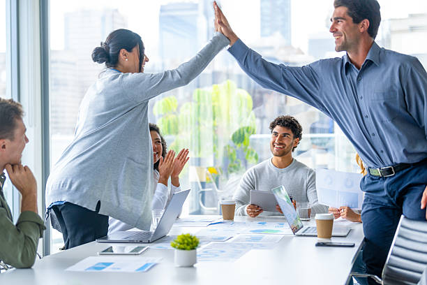 istock Business team members giving each other a high five celebration 2217031750