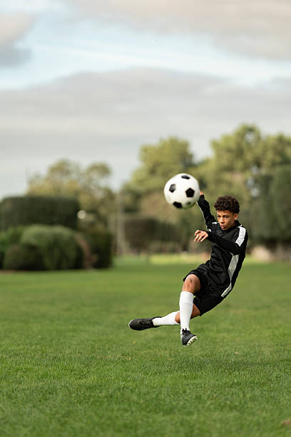 istock Soccer player kicking ball on the field 2217034457