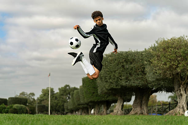 istock Teenage boy doing trick with soccer ball 2217034484