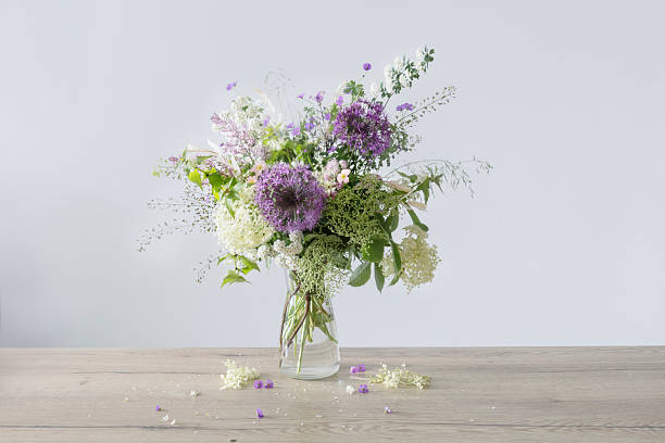wildflowers in glass vase on wooden table stock photo