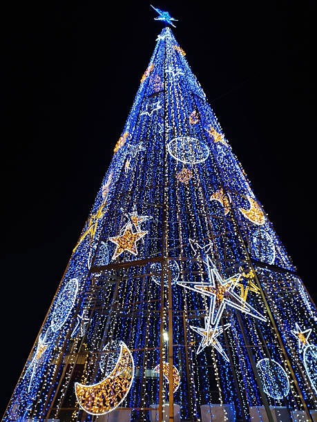 istock Magnificent illuminated Christmas tree against a night sky. Festive, joyful image for holiday greetings, event promotions, winter celebrations, and seasonal designs. 2217040139
