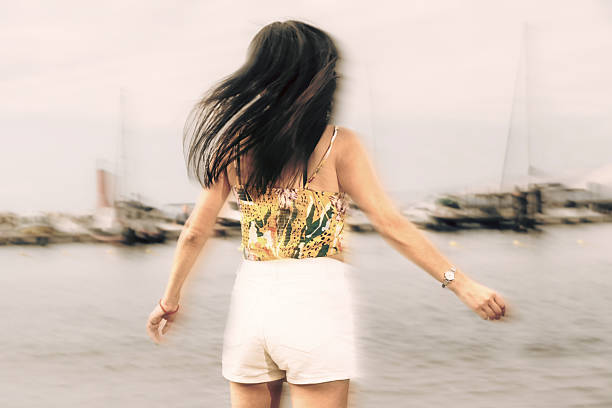 unrecognizable woman dancing and enjoying the beach